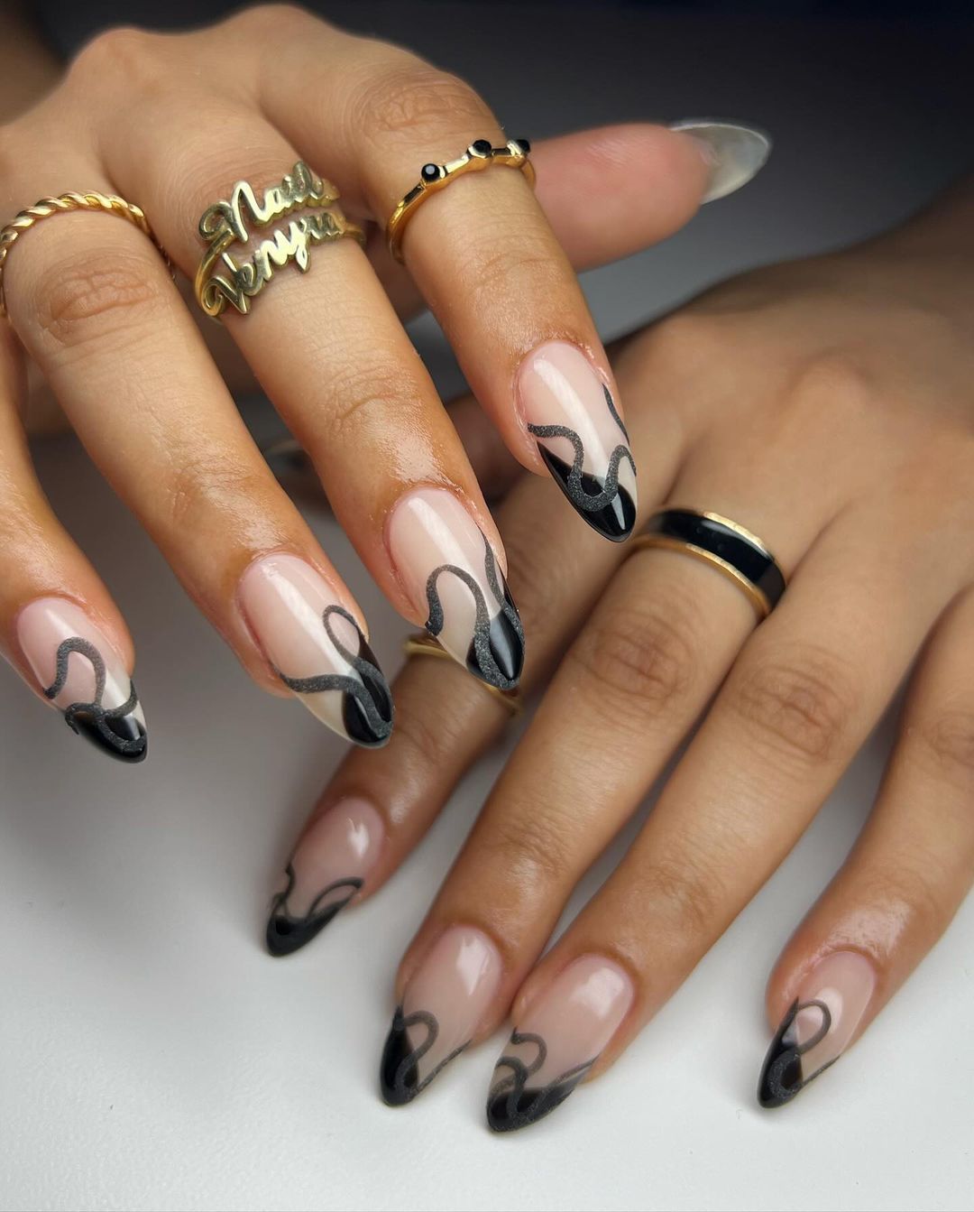 Close-up of a person's hands with black nails having Complex Geometric Patterns
