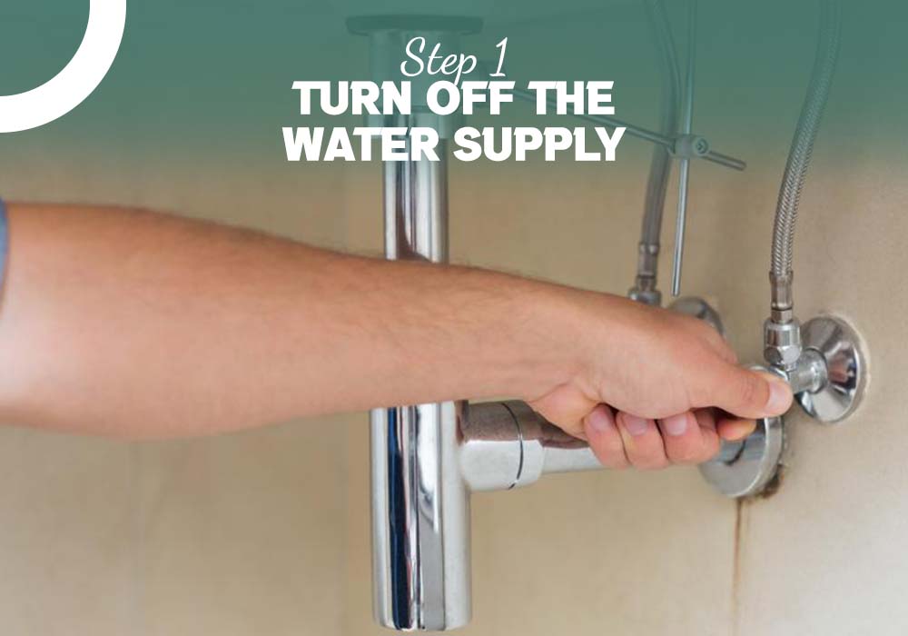 A man is turning off the water supply while learning how to fix a leaky bathtub faucet with two handles.