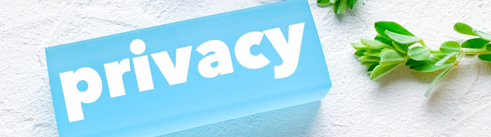 「privacy」の白文字が入った水色プレートとグリーンの小枝を組み合わせたイメージ