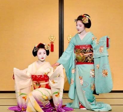 Two women in traditional japanese clothingDescription automatically generated