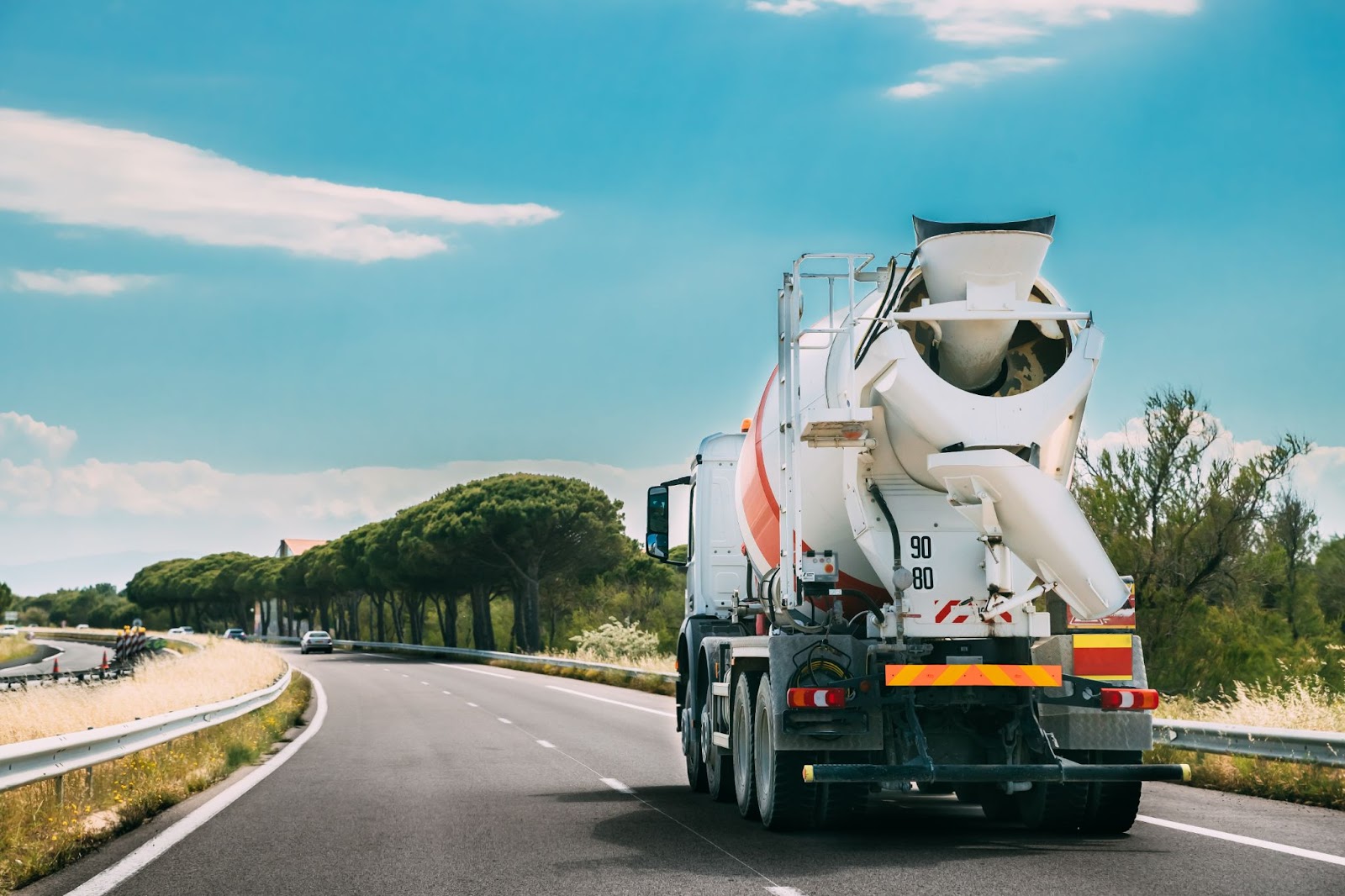 A shot of the back of the concrete mixing truck traveling on a highway.