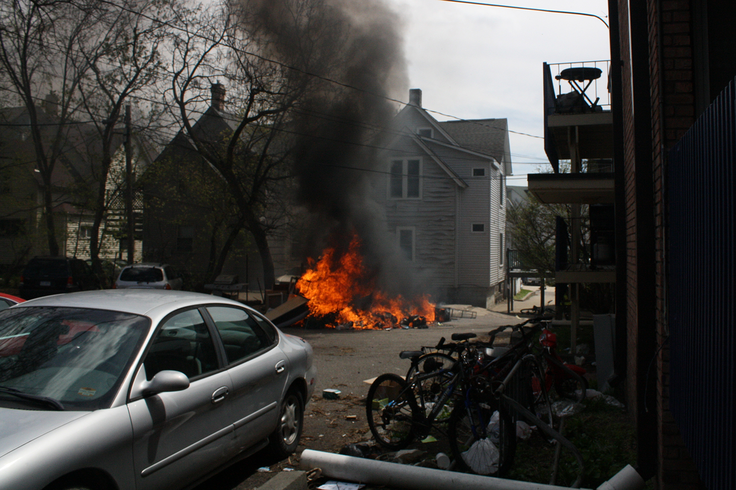 Dumpster burning in parking lot behind houses in Ann Arbor.