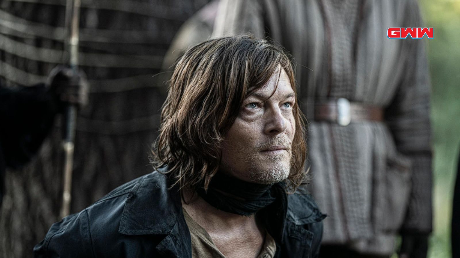 Norman Reedus as Daryl Dixon kneeling with a grim expression