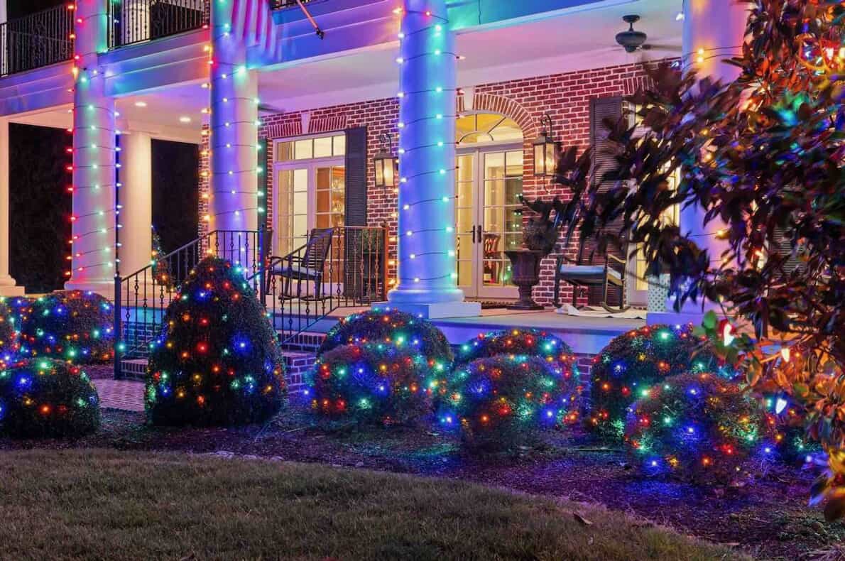 A charming home decorated with colorful Christmas lights on the front porch, radiating holiday cheer and warmth.