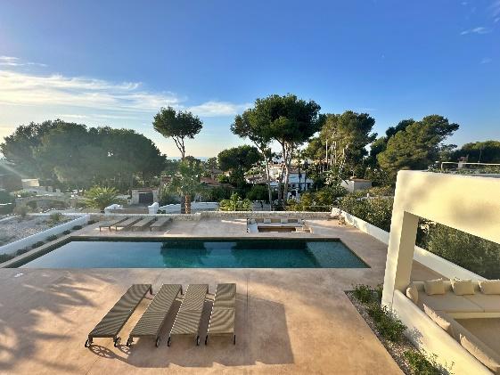 A pool with lounge chairs and trees in the background

Description automatically generated