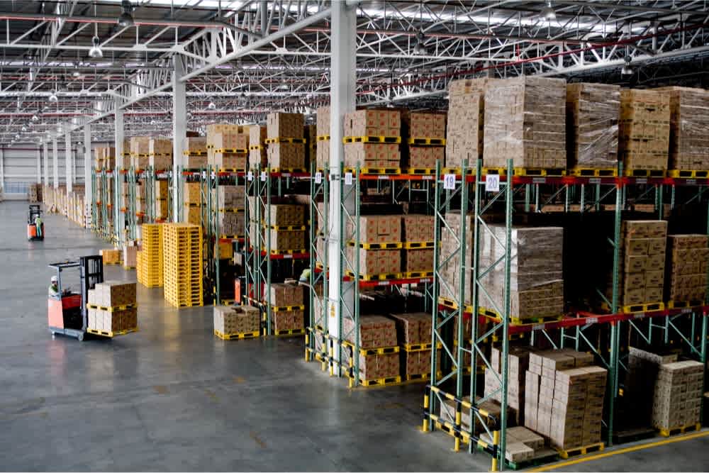 A well-organized e-commerce warehouse with stacked boxes and forklifts, illustrating secure logistics and inventory management