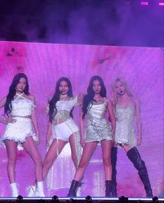 This contains a picture of BLACKPINK  members all dressed up in white outfits and performing on stage