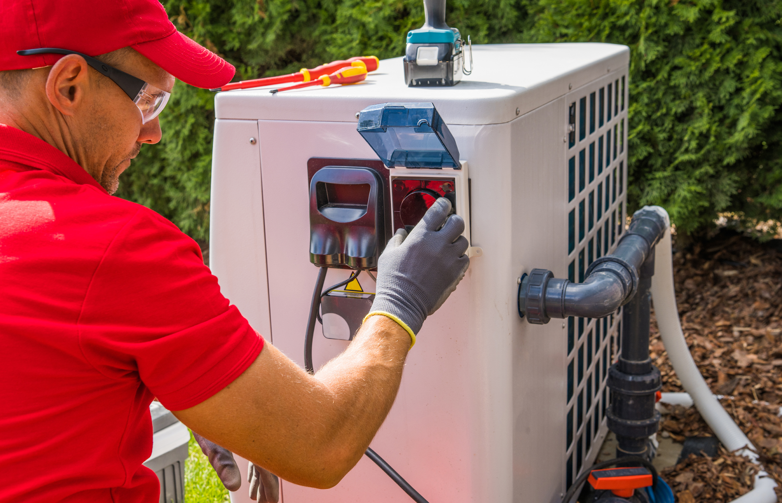 A man repairing an outdoor heat pump