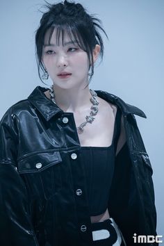 This contains an image of Red Velvet's Seulg putting on a black jacket with inner
 crop top with a necklets on her neck