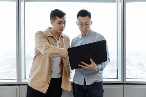 Free Man in Brown Dress Shirt Holding Black Tablet Computer Stock Photo