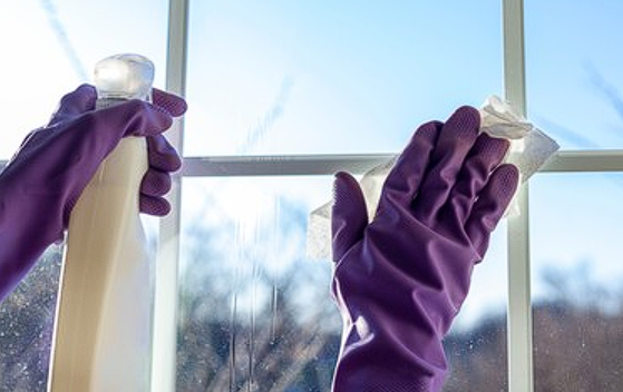 A person cleaning a window Description automatically generated