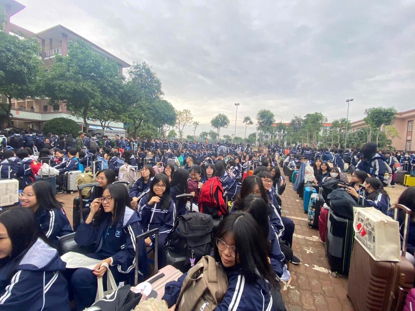 A large group of people sitting on a sidewalk

Description automatically generated