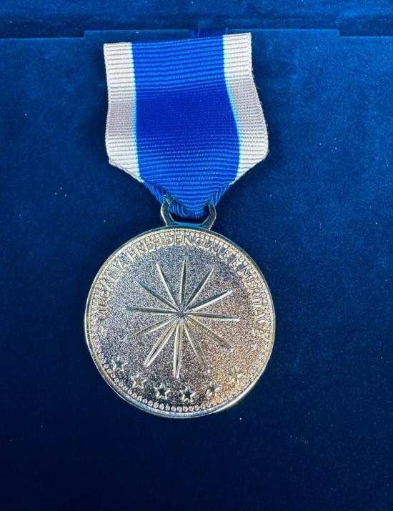 A silver medal with a blue and white ribbon AI-generated content may be incorrect.