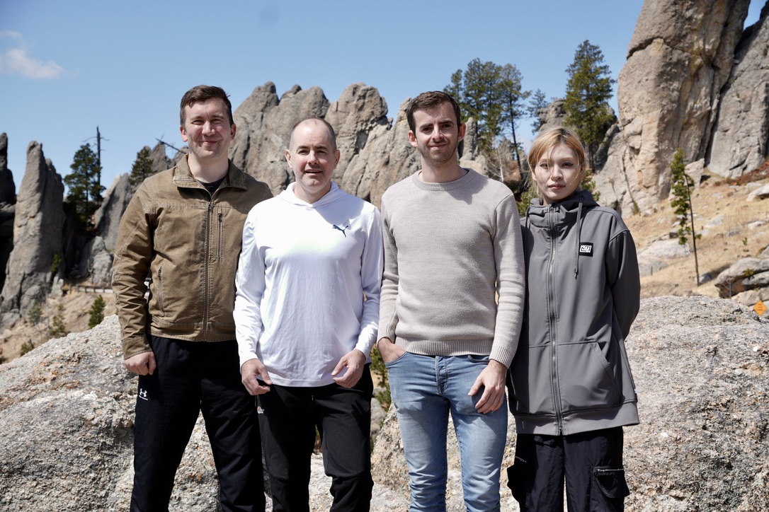 Four people stand in front of rocks 