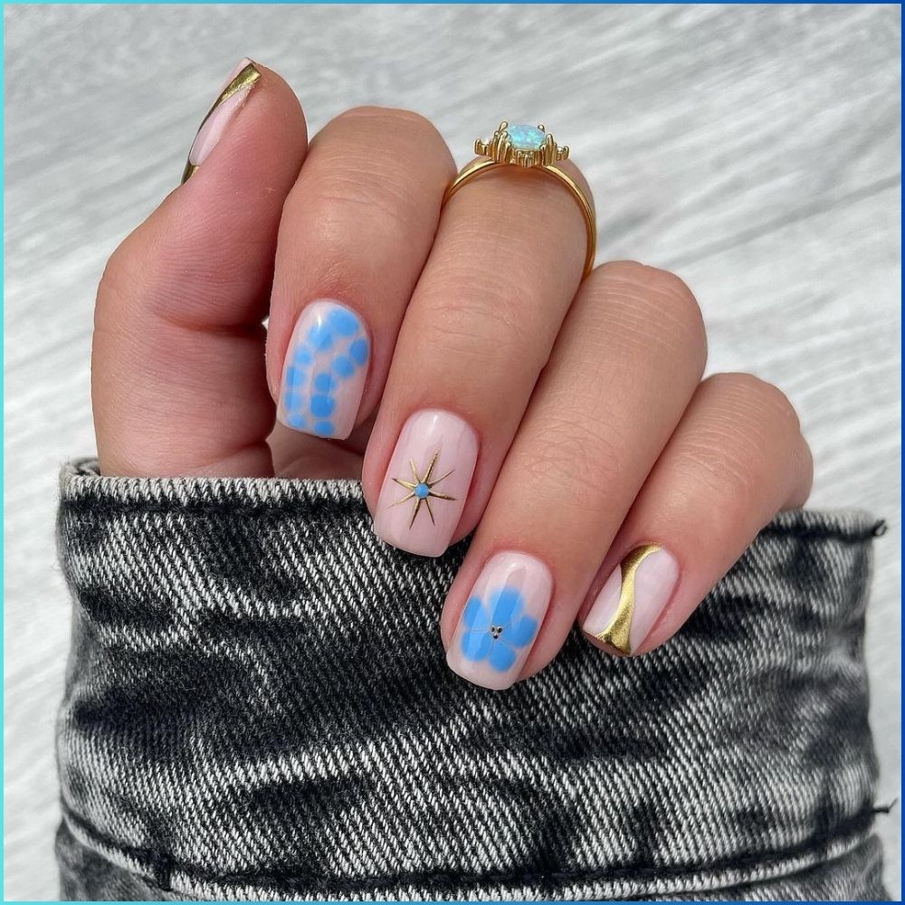 Close up of hands with flowered designed blue nails having Blue Sky theme