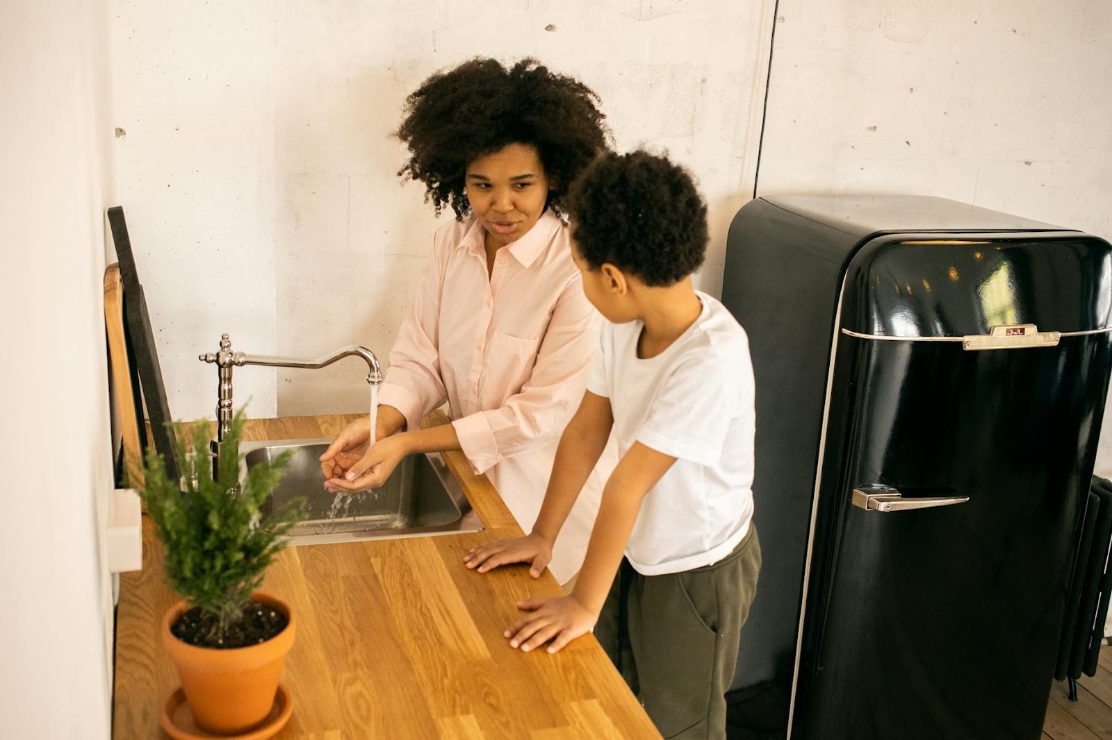 African American mother with son washing hands