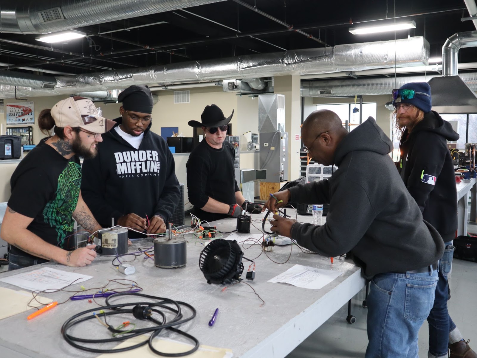 Pinnacle Career Institute HVAC Technician students working at a table on HVAC systems 