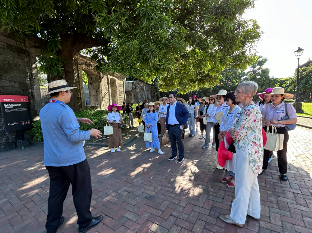 A group of people standing on a brick pathDescription automatically generated