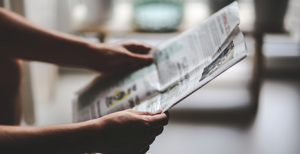 in this image a student is reading the newspaper. by https://rajiasacademy.com/