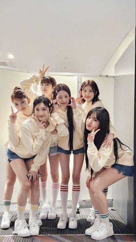 A picture of IVE members on a off-white shirt and a short jean 