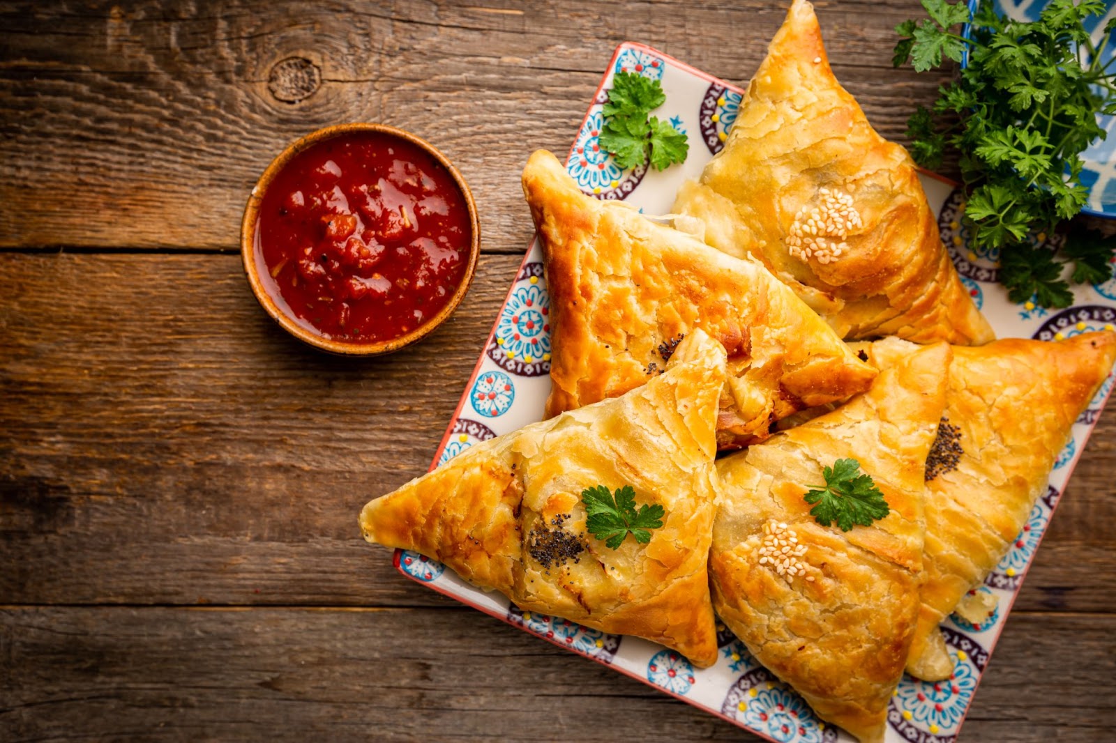 A plate of samosas with chutney.