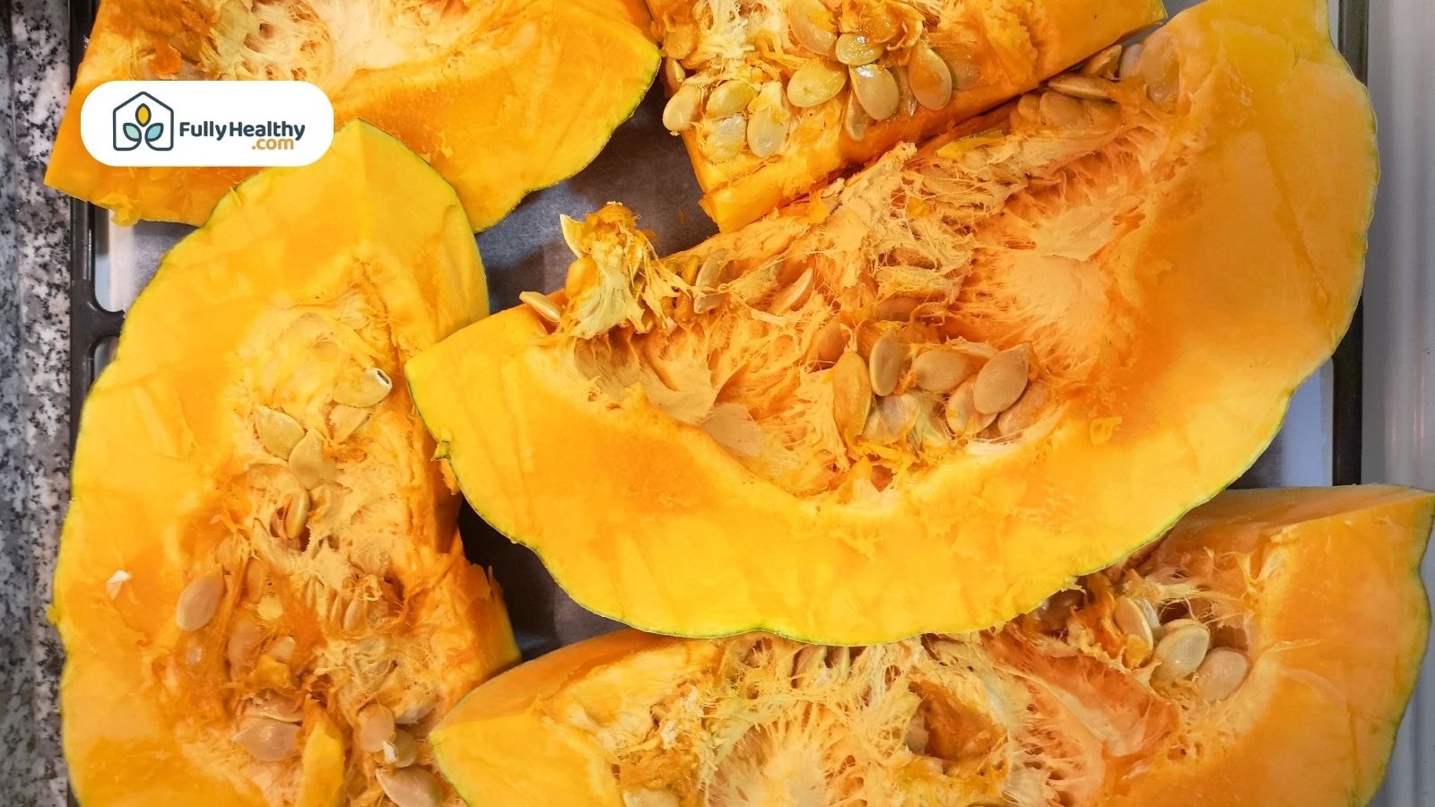 Fresh pumpkin slices with seeds on baking tray