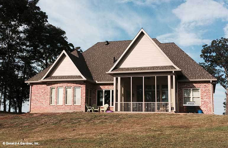Rear exterior view with a tall covered porch framed with white trims and railings.