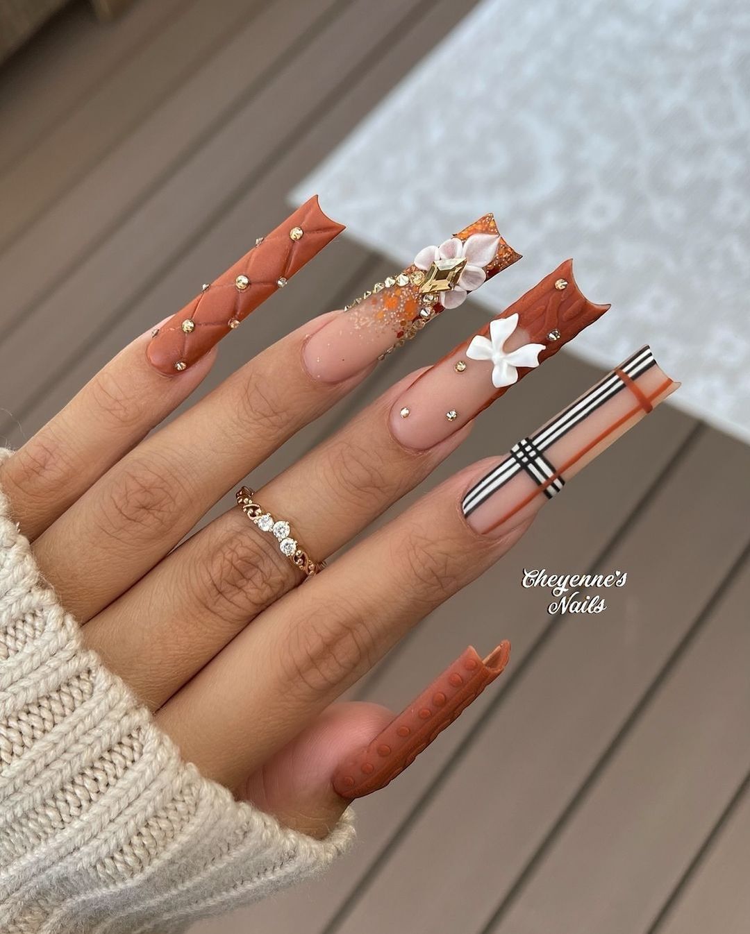 Close-up of hands with fall nail design having Fall-Colored Rhinestone Applications