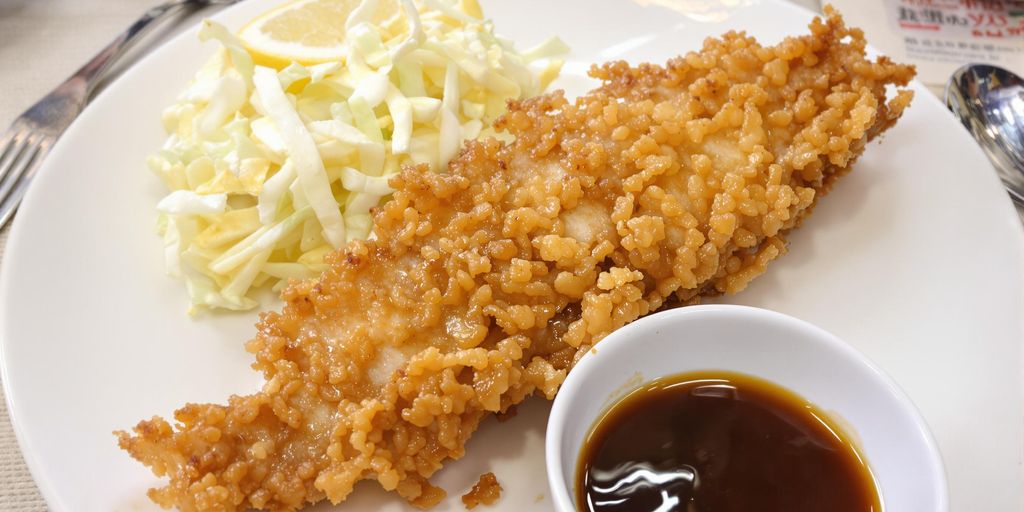 Crispy golden-brown tonkatsu with sauce and cabbage.