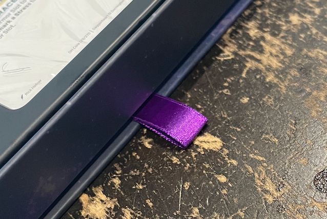It's a bit of ribbon sticking out of the bottom of the box.  It's the kind you'd pull on to open a drawer, except there's no drawer.  If you pull on it hard enough, you'll destroy the box. 