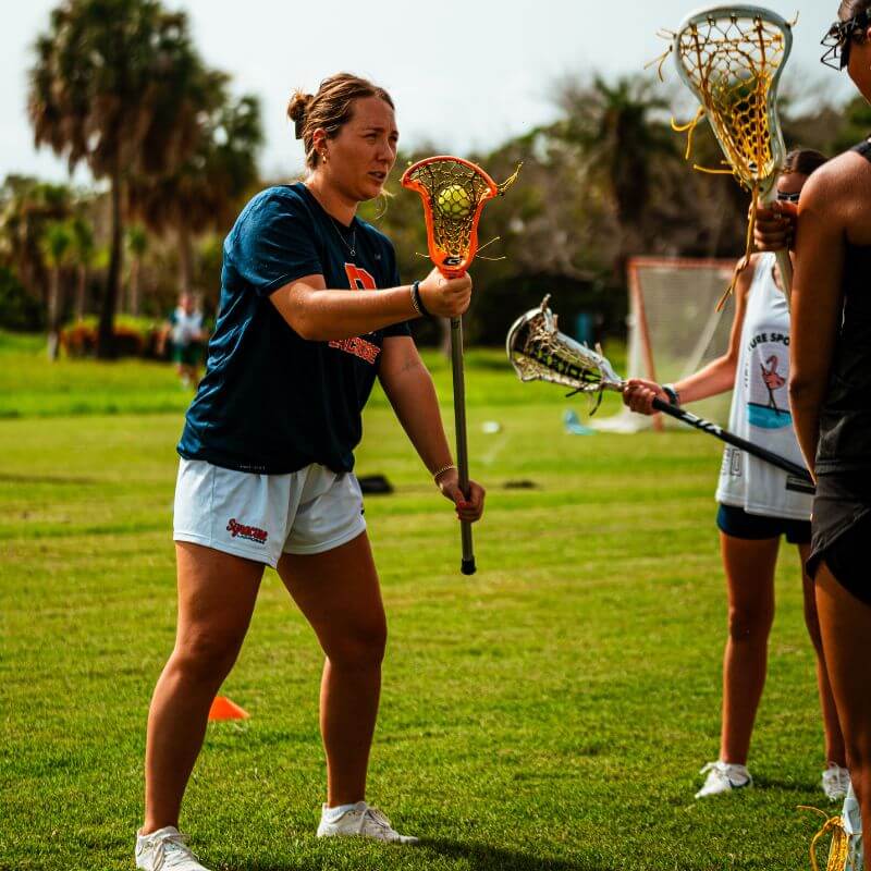 Lacrosse professional giving guidance during a training session at signature sports camps