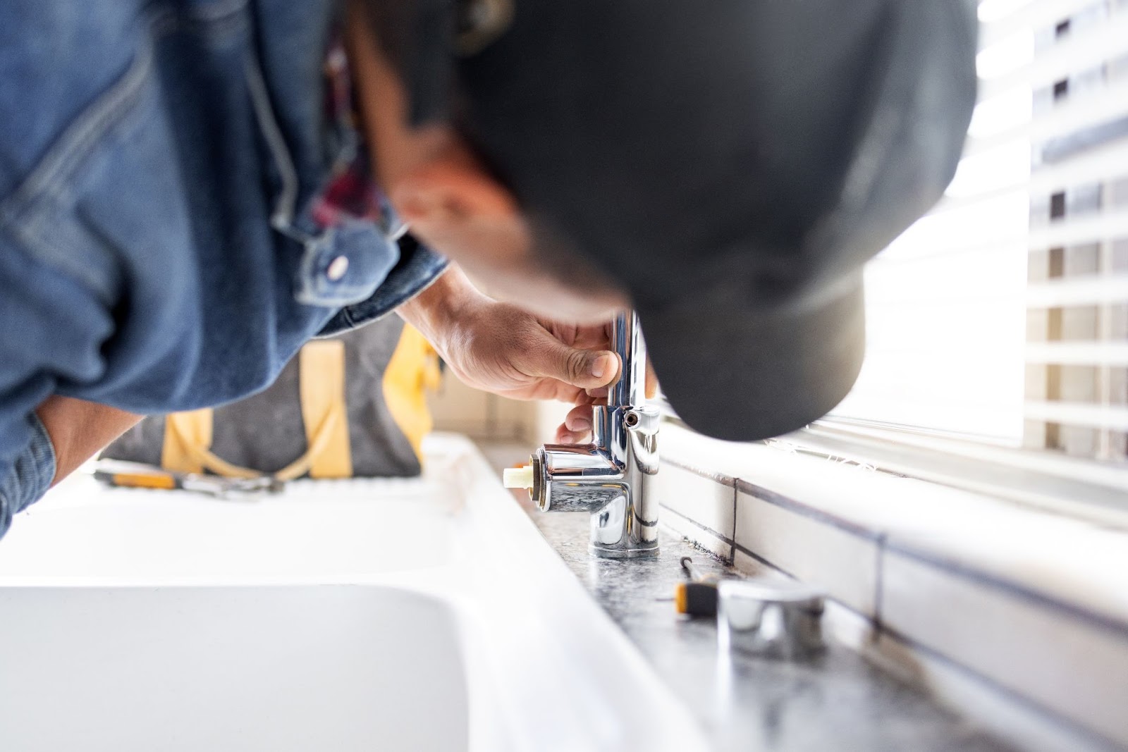 Man working on a bathroom sink repair. 