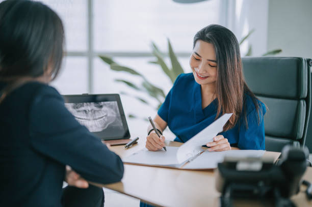 A dentist discusses financial options with a patient. 