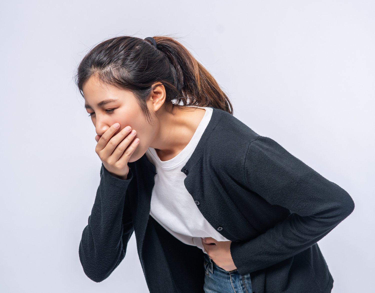 wanita memegang perut dan menutup mulut karena mual dan muntah akibat batu ginjal