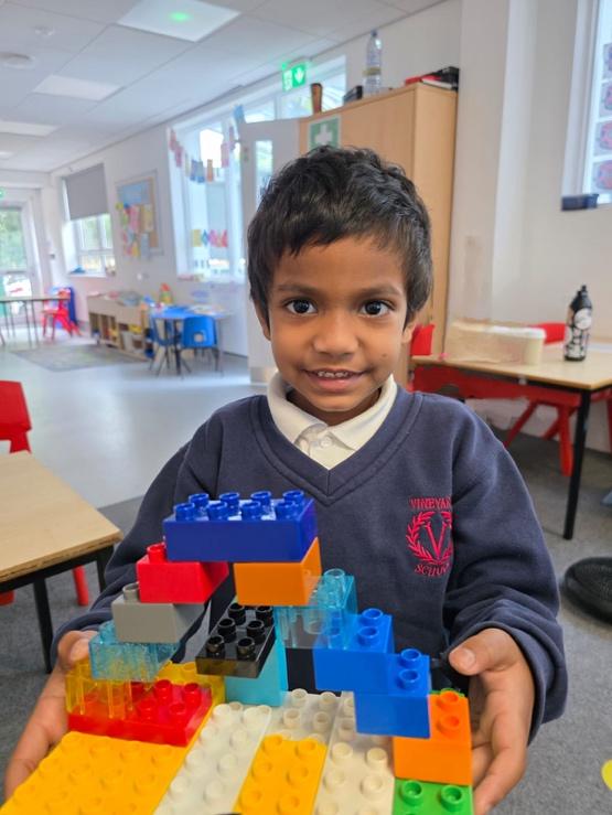 A child holding a building block

Description automatically generated