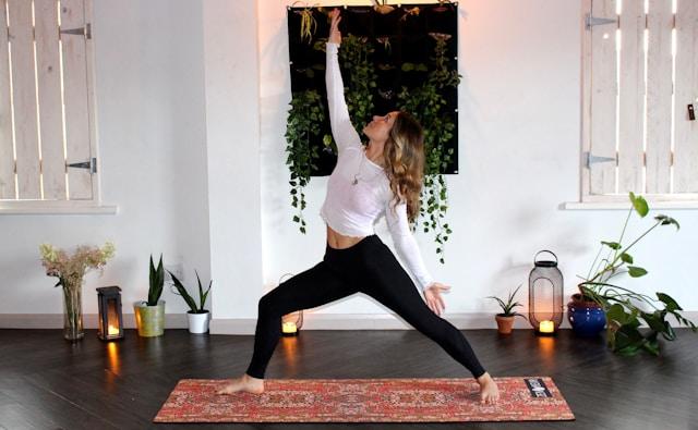 Perempuan sedang Yoga dalam ruangan dengan dekorasi di belakangnya