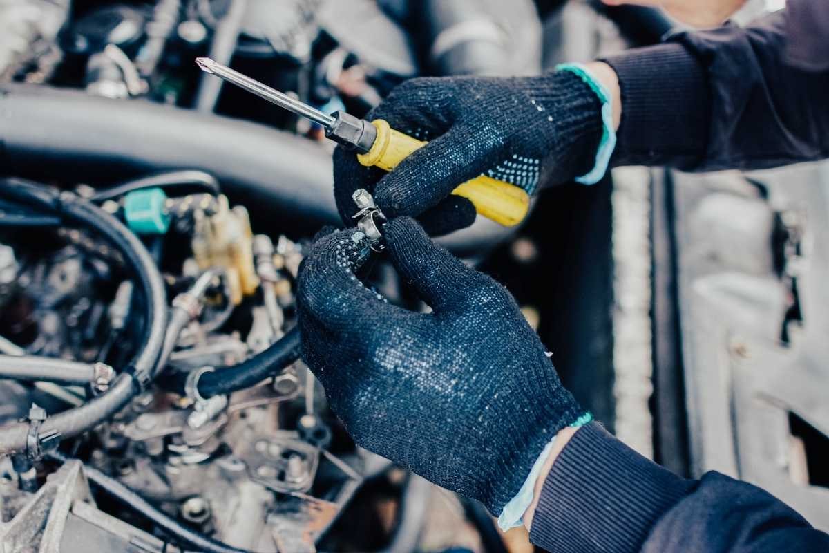 A mechanic inspecting a radiator hose.