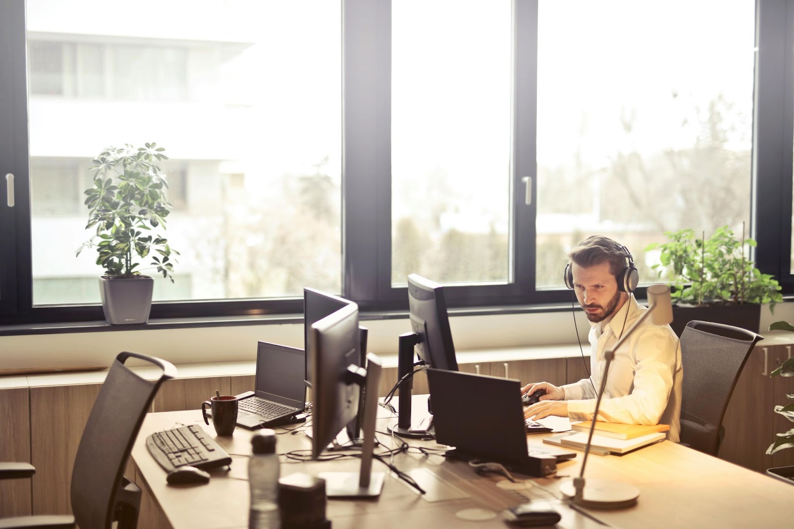 A man sitting at a computer desk with a headset on.