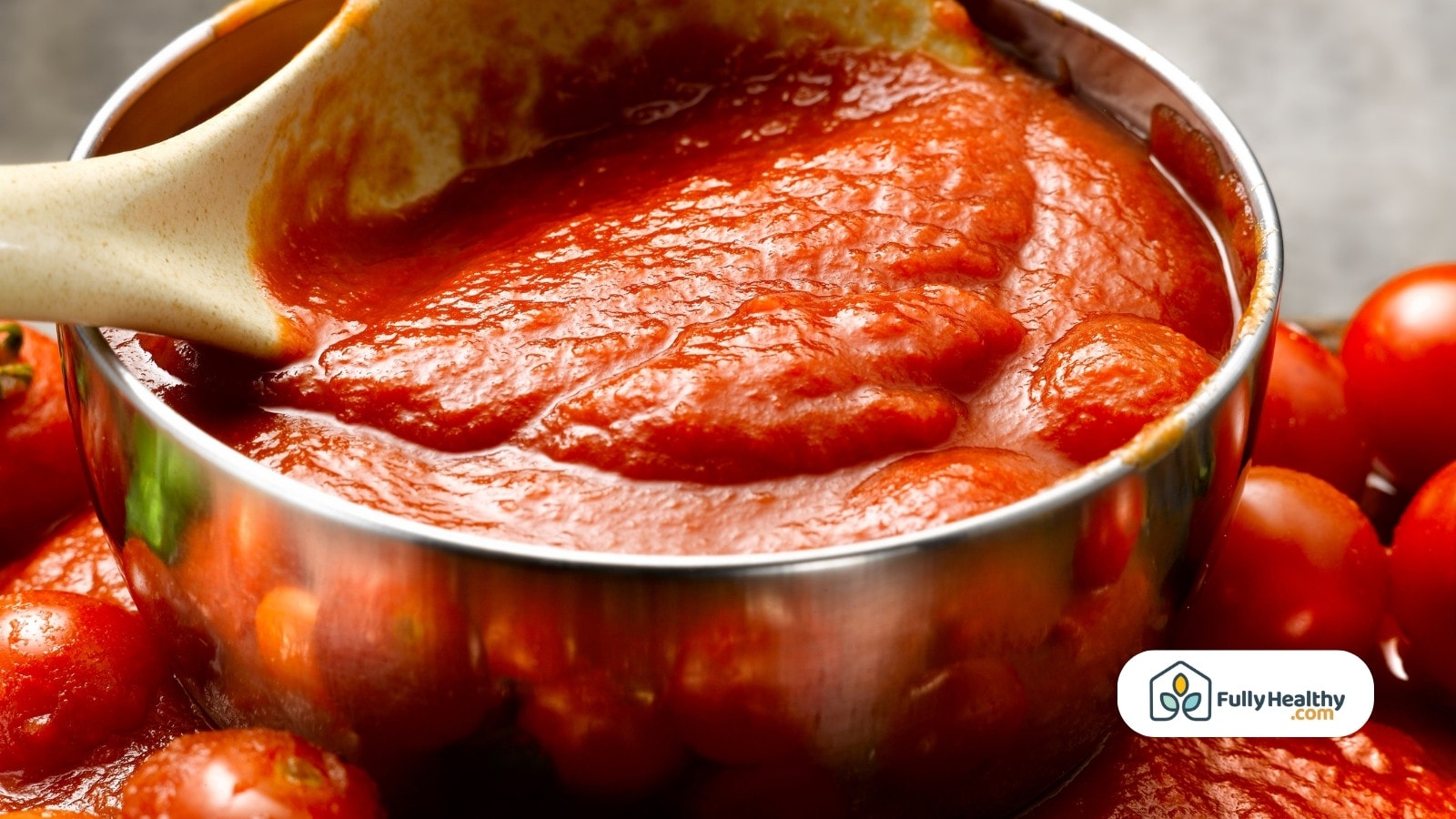 Rich tomato sauce in a pot with fresh tomatoes around it