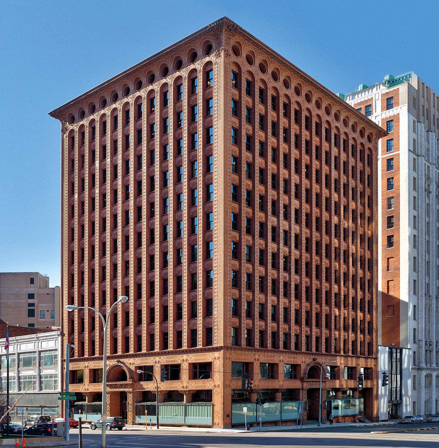 A large building with many windows with Prudential (Guaranty) Building in the background<br /><br />Description automatically generated