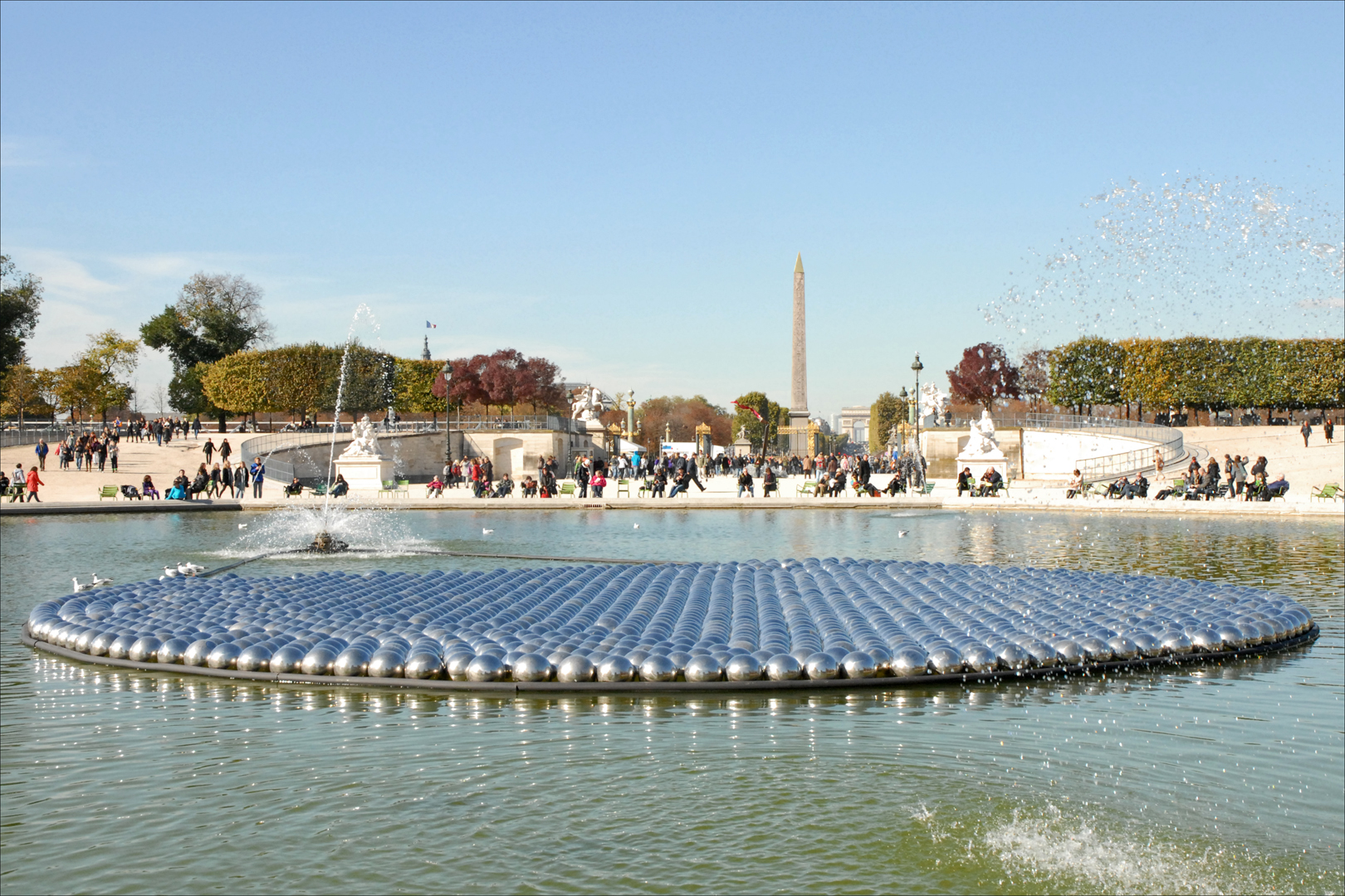 Installation. Hundreds of balls, mirrored surfaces and of uniform size, are in a circle on the surface of still water.	118	The Washington monument is visible in the distance. In the foreground we see hundreds of balls that reflect their surroundings in their mirrored surfaces. They are gathered in neat rows, forming a perfect circle, and appear to float upon the still body of water. 
Earthwork. A monumental, spiral-shaped artwork, made of rocks and earth, stretches out into a body of water. 	109	This rocky structure stretches out across the water from a bright white shoreline. The scale is very large, a human could easily walk on top of this structure and follow its trajectory for several hundred feet. The structure resembles a rough, rocky pathway, about ten feet across, that extends from the shoreline out into the water in a straight line until it begins to curve, about a hundred feet in. At this point, the rocky path over the water forms a spiral pattern. The path of rocks winds inward in diminishing spirals until it ends at the center. 
Installation. View of barren trees and a pathway with bright orange structures and tall buildings in the background.	119	The view of a park shows a walking paths, decorated with bright orange fabric. Each piece of fabric is supported by rectangular structures that allow it to hang and billow in the wind, tall enough for human beings to easily walk through.  
Installation. A permanent pathway stretches into the distance, bending sharply to the left, grass on both sides.	112	On the horizon are trees with fall-colored leaves, placing this constructed path in a park-like setting. Down the left side of the path is a simple barrier of posts and chains. Down the right side is a smooth, reflective wall that increases in height as the path slants downward, more deeply into the earth. There is writing on the wall in regular rows. 
Installation. Interior view of a kitschy barber shop with red chairs, a pool table, checkered floor, and framed photos.	119	At least twenty-five decorative pieces adorn the mustard-yellow walls in neat rows. Though they resemble ceramic ware, upon closer inspection they are actually hubcaps, interspersed with framed pictures of men's faces. Directly across the room from our vantage point is a large mirror, on top of which sit trophies and a hat. Under the mirror is a surface cluttered with various tools typical of a barbershop. There are three red chairs facing toward us as if waiting to welcome customers. Strapped to the top of each chair is a small video monitor. Reflected in the mirror are dozens of additional framed photographs, giving the sense an immersive experience. 
Installation. View of a concrete floor from high above. A crack divides the surface, several people observe the space.	118	There are four individuals visible in this image, one stands between two branches of the large crack, one stands on the crack itself. Another appears to be walking by, as the other figure stands still, off to the side. The human figures give a sense that the scale of this piece is massive. 