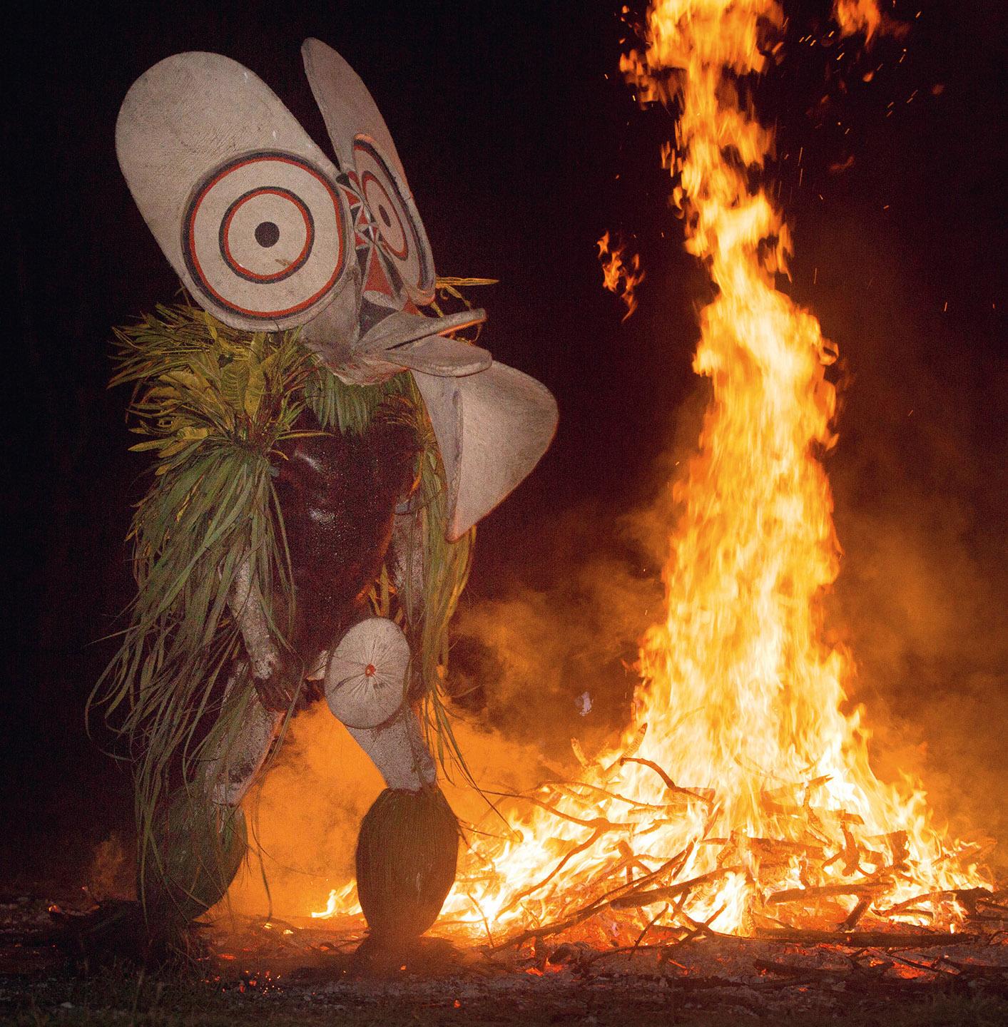 A person in a garment next to a fire

Description automatically generated