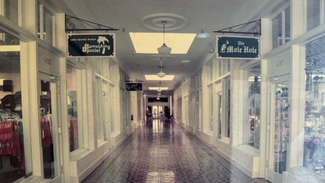 Long hallway with signs from ceilingDescription automatically generated