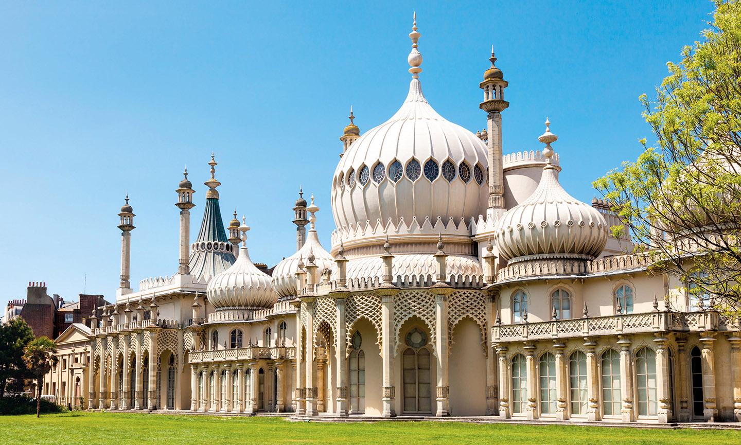 A large building with a lawn with Royal Pavilion in the background<br /><br />Description automatically generated