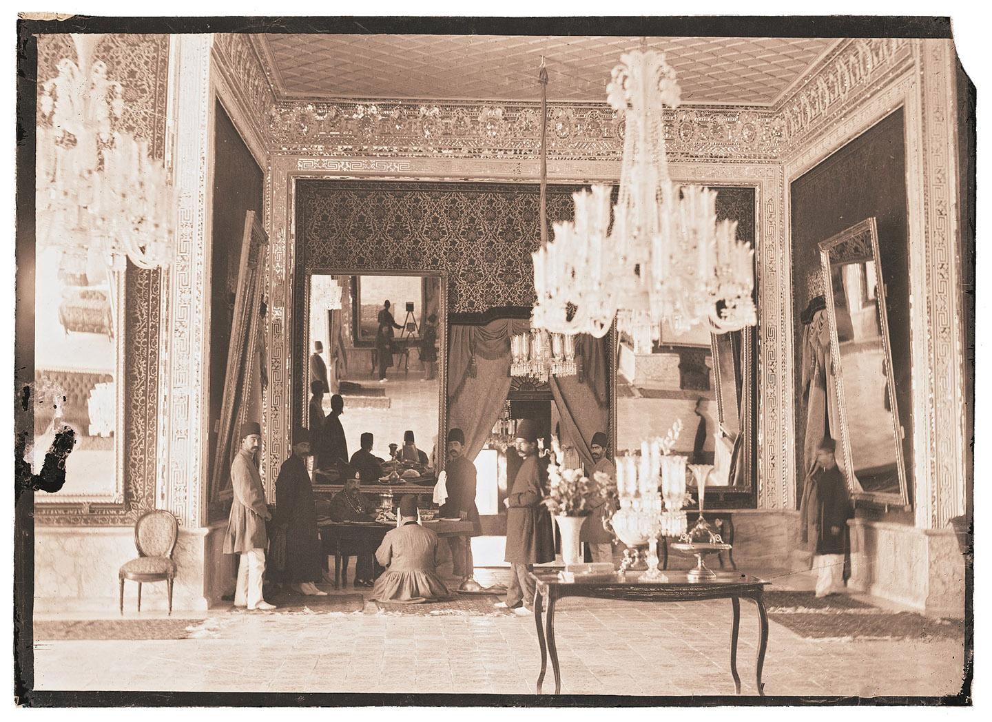 A room with chandeliers and people

Description automatically generated